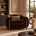 Load image into Gallery viewer, A dark brown velvet armchair with a textured beige throw pillow, set in a beautifully styled living room with a stone side table, potted plant, and warm ambient lighting.
