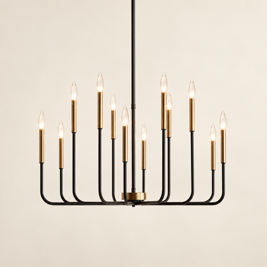 A modern 12-light chandelier with a matte black metal frame and brushed brass cylindrical candle-style bulbs, suspended against a warm off-white background.