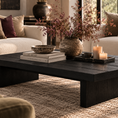 Load image into Gallery viewer, A dark charcoal coffee table in a styled living room setting, decorated with a ceramic vase of dried branches, books, a bowl, and two lit candles.
