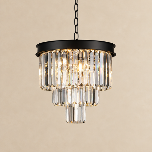 A modern tiered crystal chandelier with a matte black metal frame and hanging chain, shown against a warm beige background.