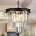 Load image into Gallery viewer, 3-tier black crystal chandelier with matte black frame and clear crystal prisms hanging in a modern room
