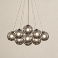 Load image into Gallery viewer, Black globe chandelier with smoked gray glass shades and suspended pendant lights against a neutral background
