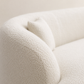 Load image into Gallery viewer, boucle curved sofa close-up of corner with a matching throw pillow, showing the soft textured fabric against a neutral light beige background.
