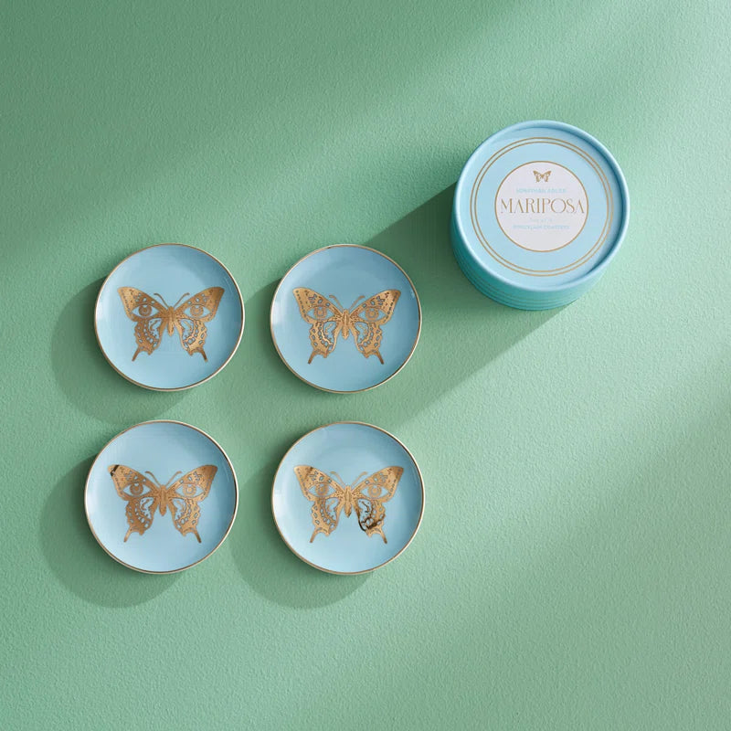 butterfly coasters on a green table next to their container