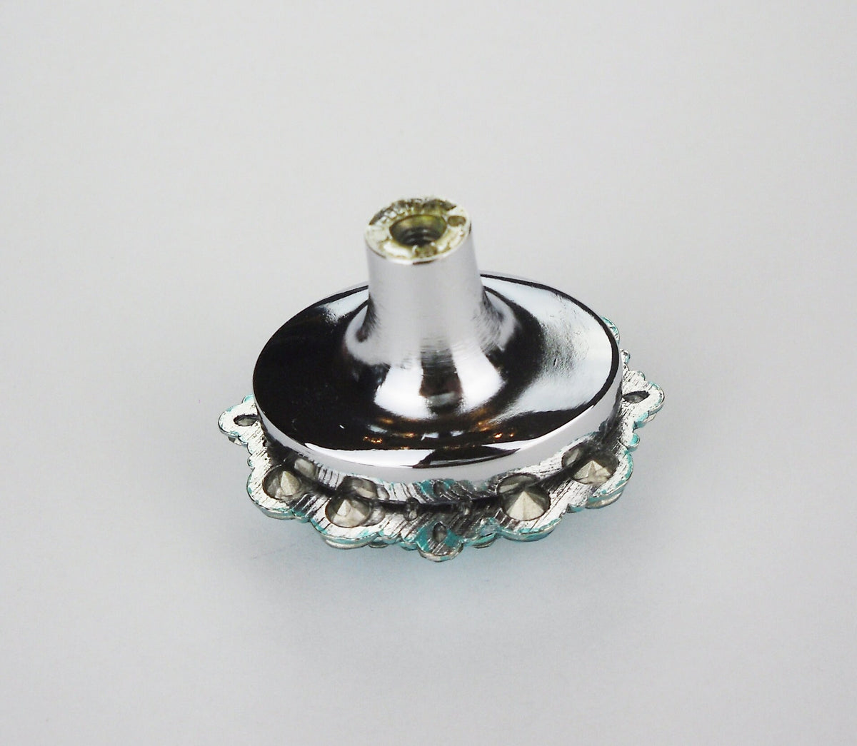 Polished nickel cabinet knob base with turquoise crystal accents on a plain white background
