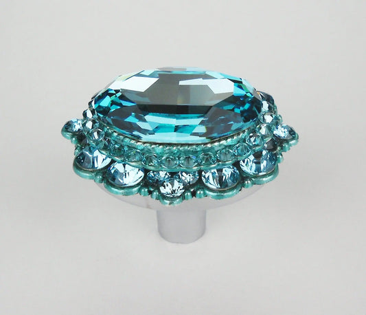 Elegant turquoise crystal cabinet knob with faceted oval center and round accents on polished silver base on white background