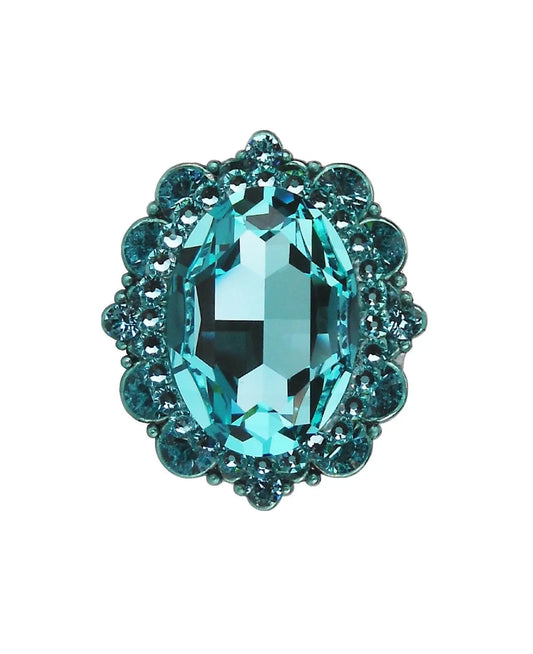Oval turquoise crystal cabinet knob with decorative smaller stones in polished silver setting on white background