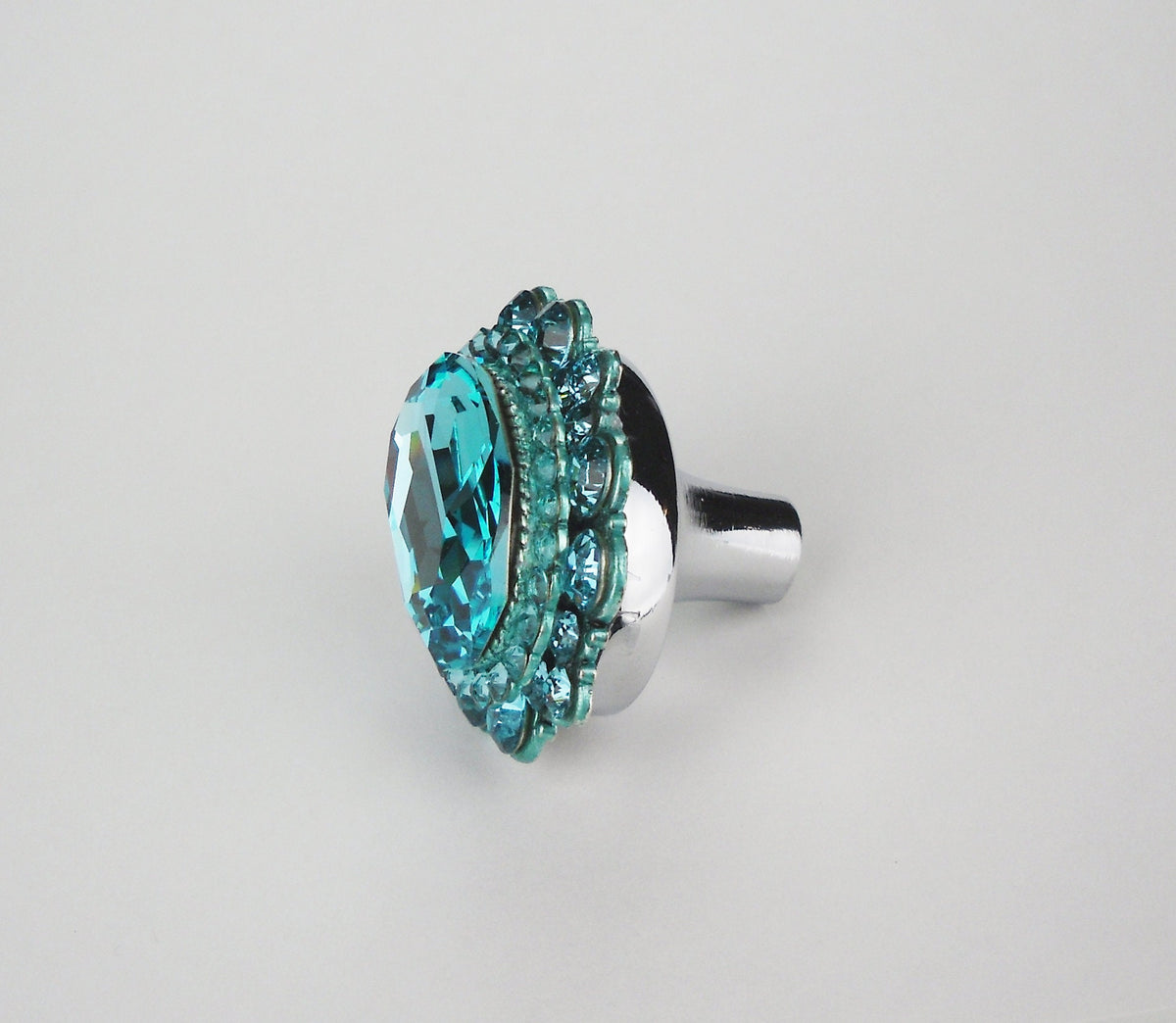 Light turquoise crystal cabinet knob with polished nickel base and decorative rhinestone accents on white background