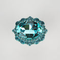 Load image into Gallery viewer, Oval turquoise crystal cabinet knob with intricate faceted detailing and polished metal base on white background
