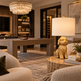Load image into Gallery viewer, Cavadoodle lamp with a sculptural gold dog base and cream linen shade on a marble side table in a luxury game room with a pool table.
