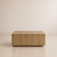 Load image into Gallery viewer, A modern rectangular coffee table made of light oak wood with visible grain, set against a minimalist beige wall and tiled floor.
