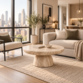 Load image into Gallery viewer, A modern living room scene featuring a round beige marble coffee table as the central product, styled with a beige armchair, a cream sofa, a textured rug, and a large window overlooking a city skyline.
