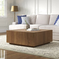 Load image into Gallery viewer, Square wooden coffee table with rustic finish on patterned rug in bright living room with beige sofa and blue pillows
