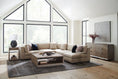 Load image into Gallery viewer, Contemporary living room with beige sectional sofa, geometric wooden coffee table, gray area rug, and large black-framed windows
