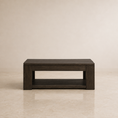 Load image into Gallery viewer, A rectangular dark brown wooden coffee table with an open lower shelf, set against a neutral beige wall and tiled floor.
