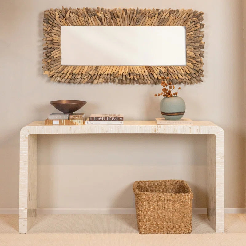 console table with books and a decorative bowl and vase on it