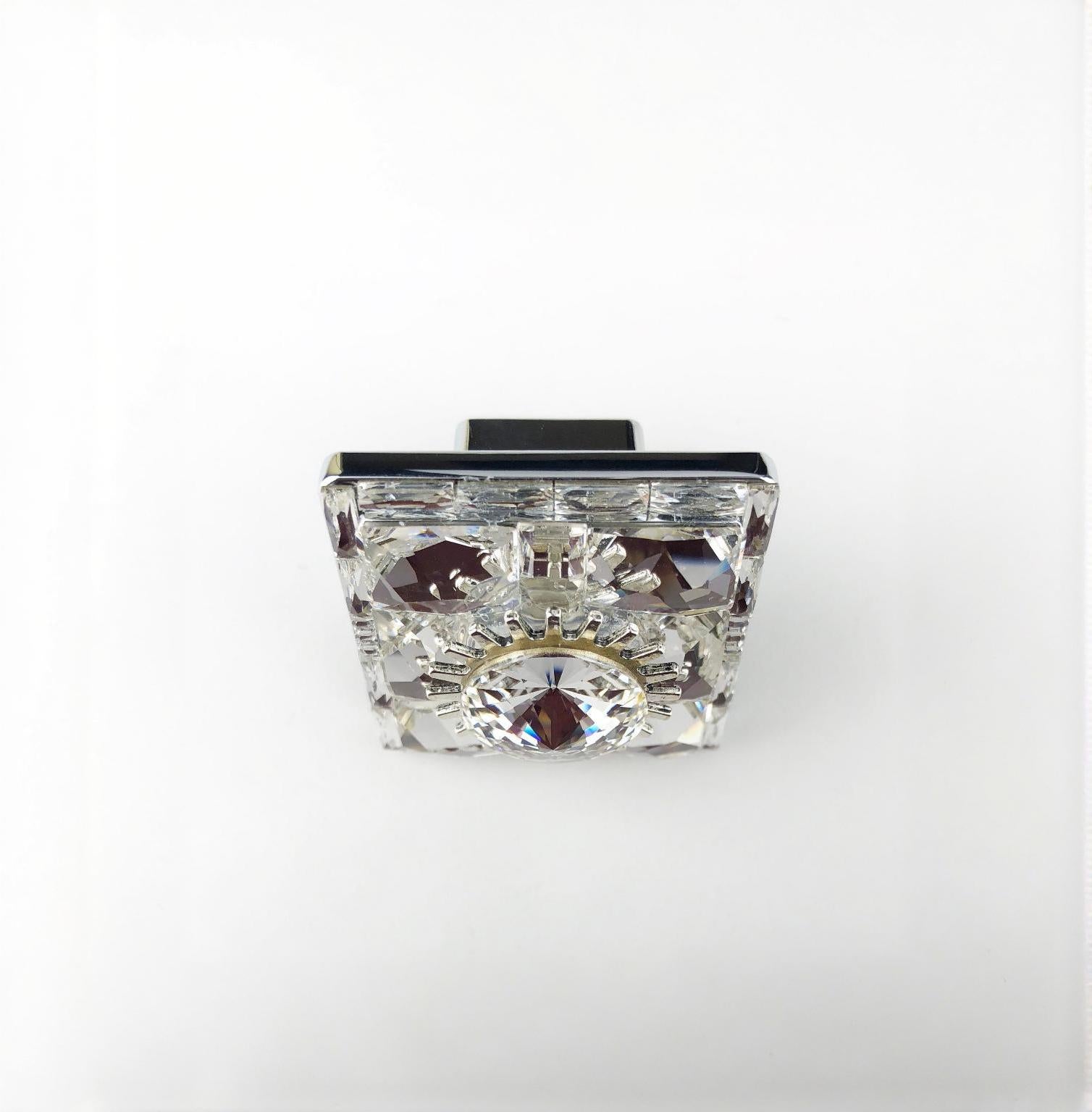 Square 1 1/2 inch crystal knob with faceted design and silver metal base on white background