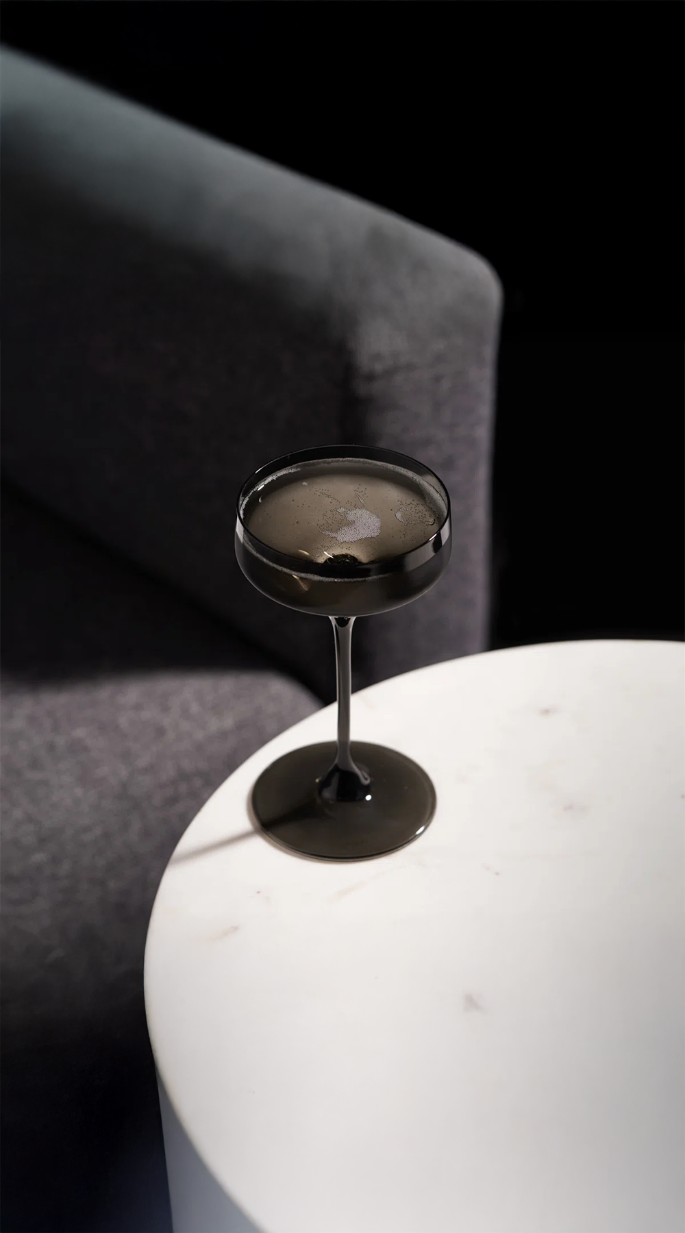 crystal wine glass being used and sitting on a white table in front of chair