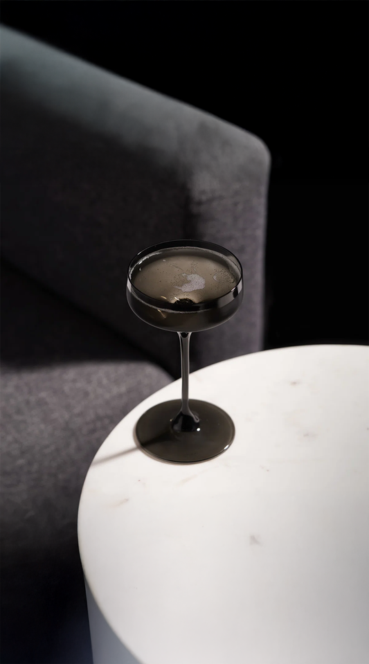 crystal wine glass being used and sitting on a white table in front of chair