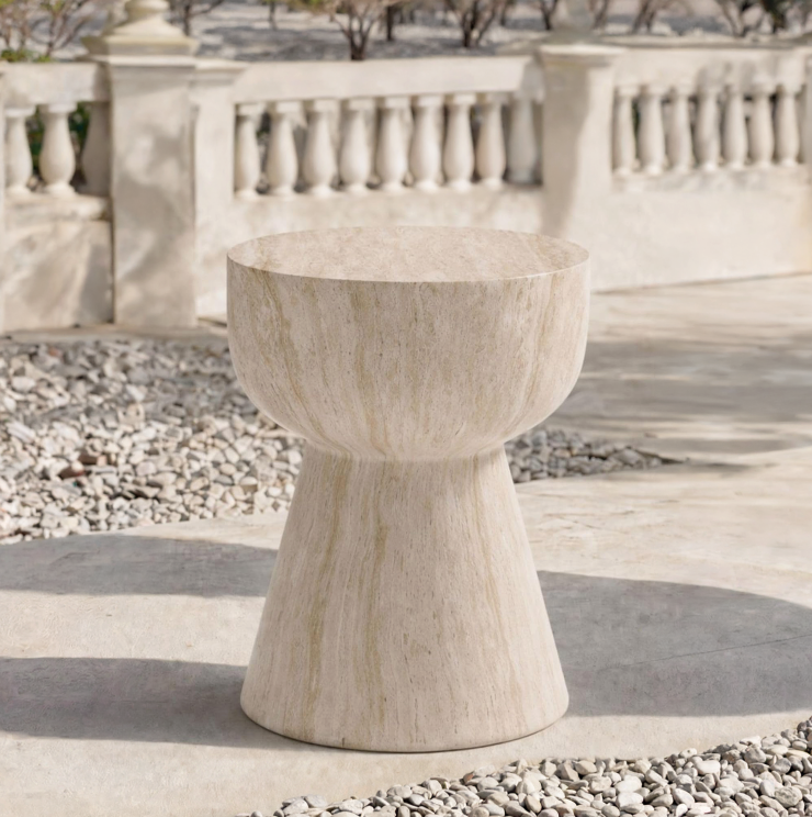 ELLA ACCENT TABLE outside next to stones on a concrete porch