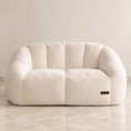 Load image into Gallery viewer, A cream-colored, plush boucle-texture two-seater sofa with a rounded, bubble-like silhouette, set against a neutral beige wall and light marble floor.
