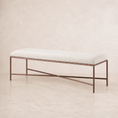 Load image into Gallery viewer, A modern fabric bench with a light beige upholstered cushion and a textured bronze metal frame, set against a neutral beige background.
