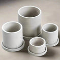 Load image into Gallery viewer, Four cylindrical MINIMALIST FLOWER POTS by House of Effy of varying sizes are arranged on a flat surface. Each light gray minimalist flower pot has a matching saucer beneath it.
