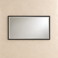 Load image into Gallery viewer, A rectangular wall mirror with a slim black frame and a thin silver inner trim, mounted on a textured beige plaster wall.
