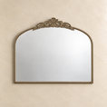 Load image into Gallery viewer, An ornate oval wall mirror with a gold scalloped frame, mounted on a textured beige wall.
