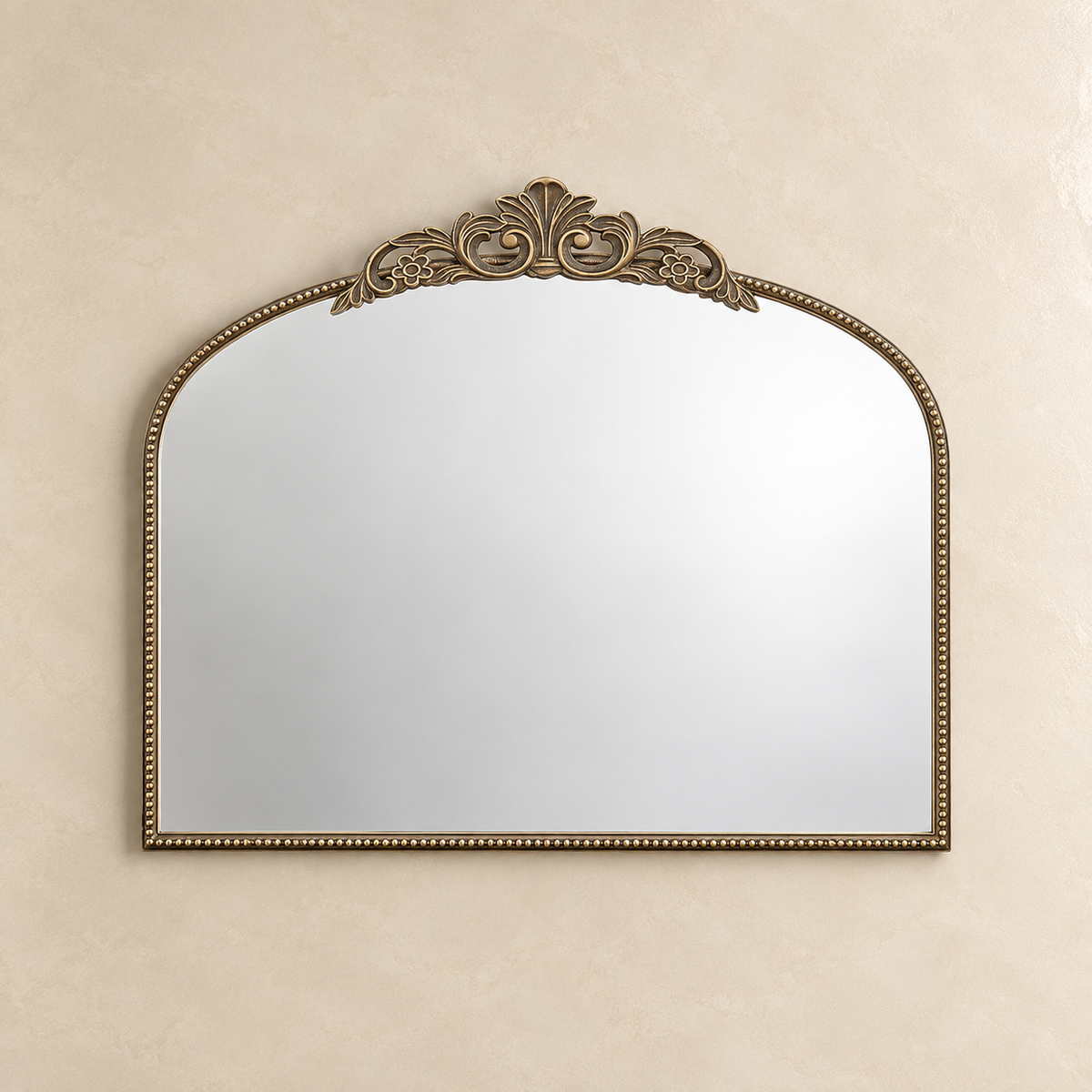 An ornate oval wall mirror with a gold scalloped frame, mounted on a textured beige wall.