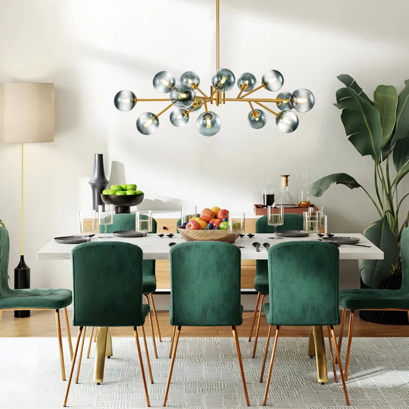 glass globe chandelier in dining room above a white table with green chairs
