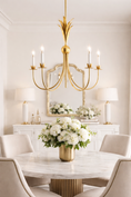 Load image into Gallery viewer, gold chandelier in dining room over a round dining table
