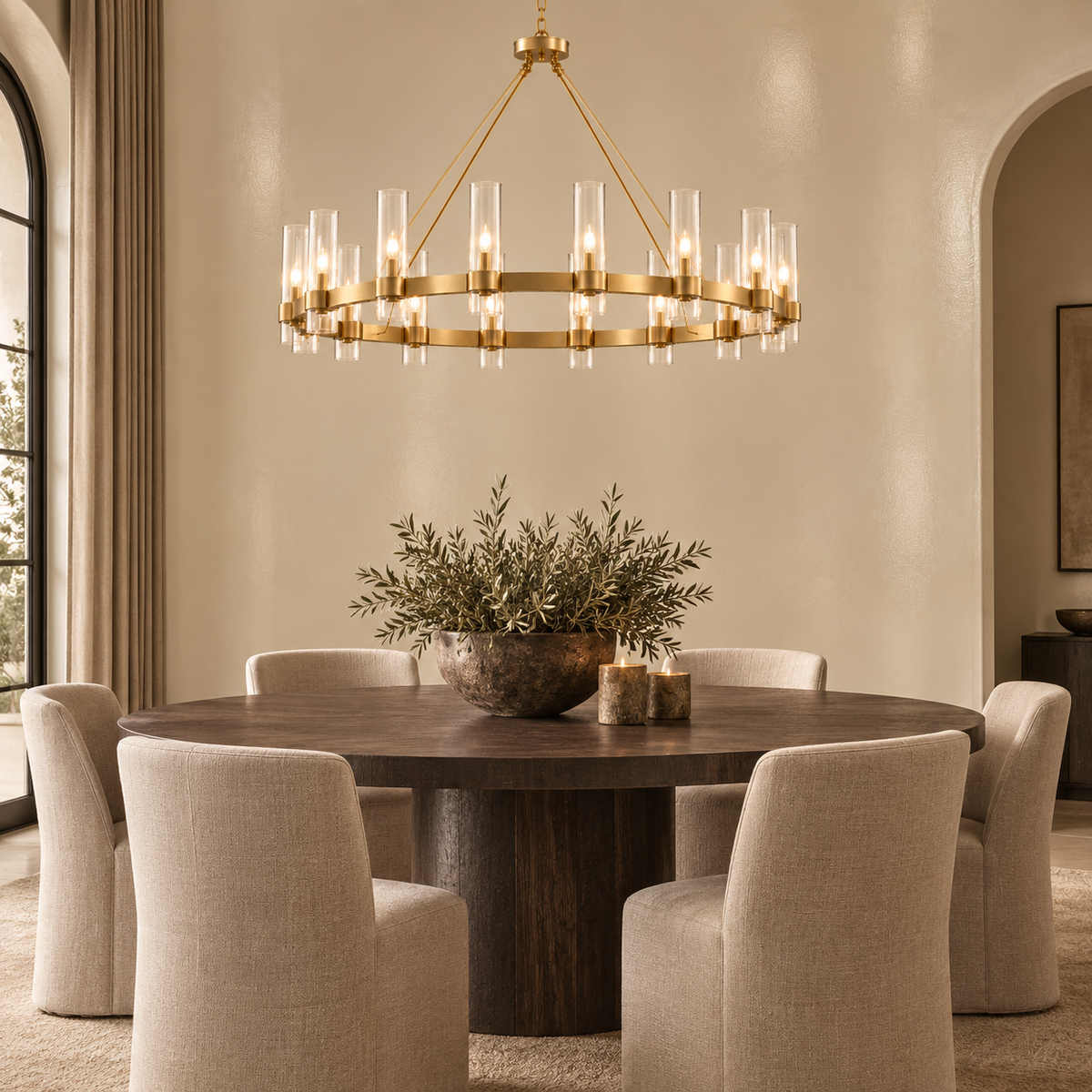 A modern circular chandelier with a gold-toned metal frame and clear glass candle-style bulbs hangs over a round dark wood dining table surrounded by six upholstered dining chairs in a warm, elegant dining room.