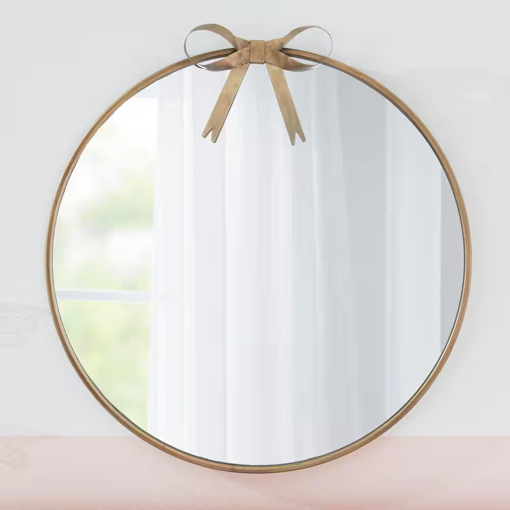 gold round mirror with bow