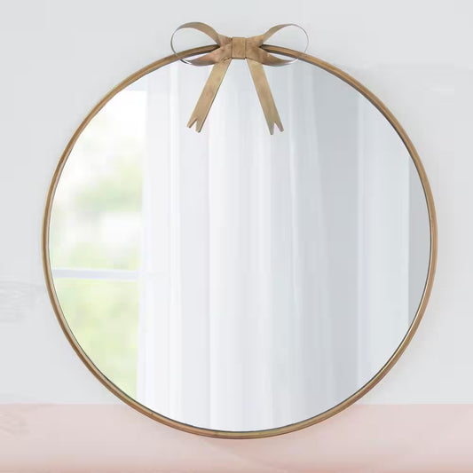 gold round mirror with bow