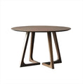 Load image into Gallery viewer, Modern round House of Effy pine wood dining table with unique interlocking legs design, positioned on a gradient gray background.
