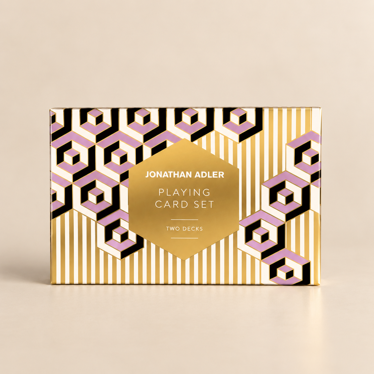 Jonathan Adler Playing Card Set box featuring a gold, white, and pink geometric pattern on a light beige background.