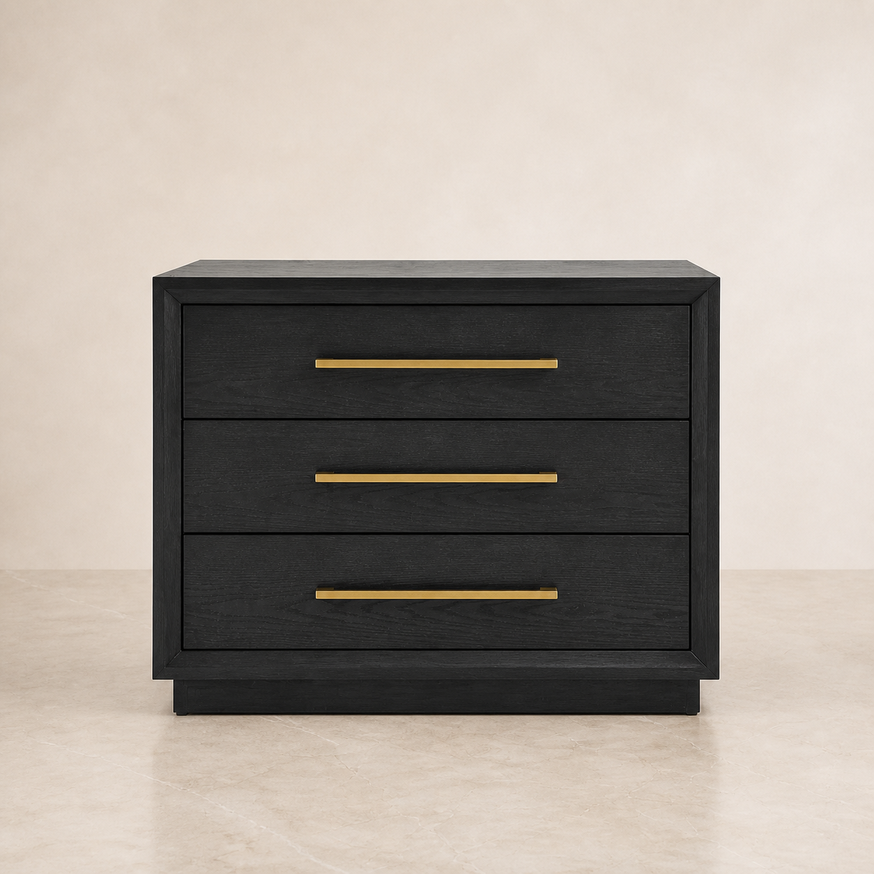 A three-drawer nightstand or side table in a dark black wood finish with slim horizontal gold metal handles, set against a neutral beige background.