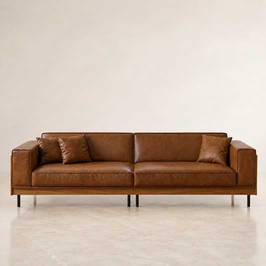 leather 2 pc sofa upholstered in warm brown leather with a matching wood-look frame and slim black legs, shown against a minimalist beige wall and floor.