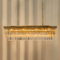 Load image into Gallery viewer, linear crystal chandelier hanging from ceiling in a room
