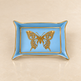 Load image into Gallery viewer, A rectangular light blue ceramic dish with gold trim and a detailed gold butterfly design in the center, set against a warm beige marble background.
