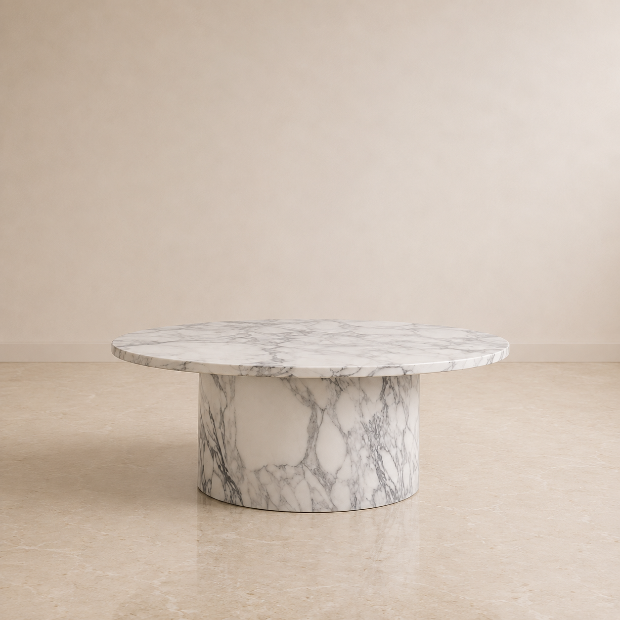 A round marble pedestal coffee table with a white and gray veined pattern, set against a minimalist beige wall and tiled floor.