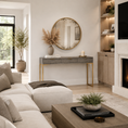 Load image into Gallery viewer, A modern living room featuring a gray console table with gold legs and trim, styled with a round gold-framed mirror, a vase of pampas grass, and a candle. The room has light wood floors, a beige sectional sofa, and built-in shelving next to a fireplace.
