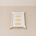 Load image into Gallery viewer, A rectangular white ceramic tray with a gold rim, featuring three embossed gold lips motifs down the center, set against a neutral beige textured background.
