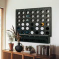 Load image into Gallery viewer, Life size black wall-mounted Four in a Row game with gold and black game pieces above wooden sideboard with decor

