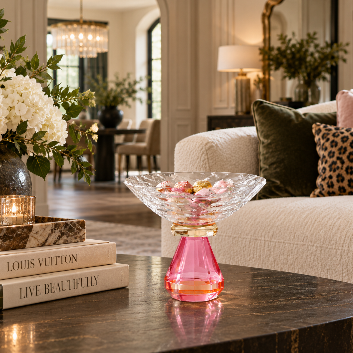 Pink crystal candy dish styled on a dark marble coffee table in an elegant living room