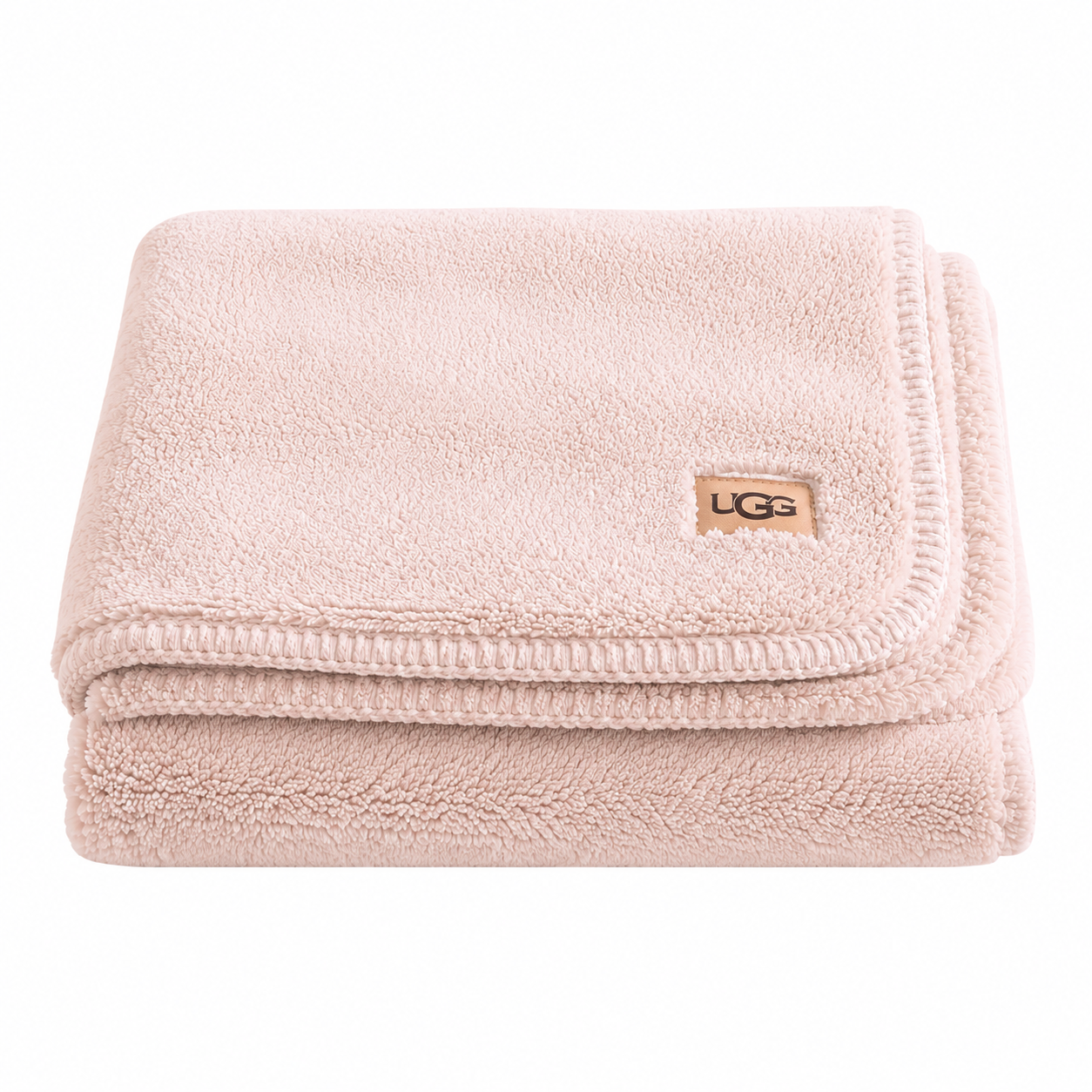 A folded light pink UGG pink throw blanket with a small tan UGG logo patch on the corner, set against a plain white background.