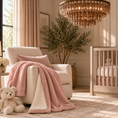 Load image into Gallery viewer, Pink UGG throw blanket draped over a cream chair in a nursery
