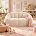 Load image into Gallery viewer, Cream bean bag loveseat styled in a girl’s playroom with soft pink accents, books, baskets and wooden toys.

