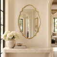 Load image into Gallery viewer, scalloped mirror in foyer above a console table with books and a vase with flowers
